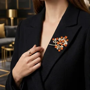 Elegant orange gemstone fruit tree brooch with sparkling stones shown on a black blazer