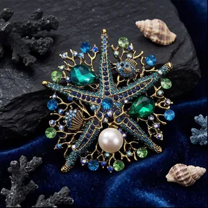 Broche estrella de mar vintage con cristales esmeralda y perla sobre terciopelo