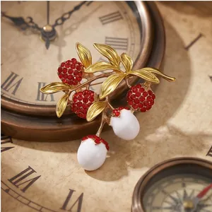 Eleganter Litschi-Frucht-Anstecker mit roten Strasssteinen auf Vintage-Hintergrund