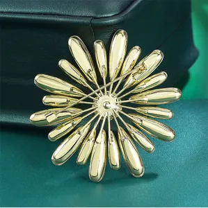 Detailed macro back view of a golden sunburst floral brooch featuring a secure metal pin clasp