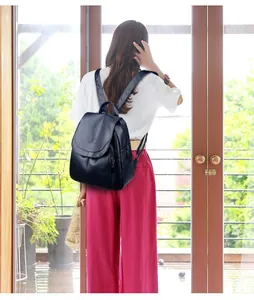 Vue arrière d'une femme élégante portant un grand sac à dos en cuir souple bleu marine