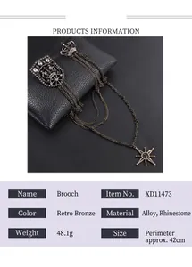 Detalle de un broche vintage de bronce con cadena larga y motivos de corona y estrella.