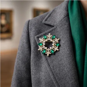 Spilla di lusso in stile corte retrò con cristalli verdi su cappotto di lana grigio.