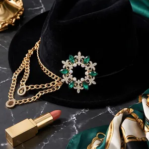 Lussuosa spilla vintage in stile corte con pietre verde smeraldo e catena dorata