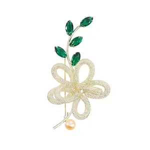 Elegante bloem speld met groene kristallen en zoetwaterparel, 14k goud verguld.