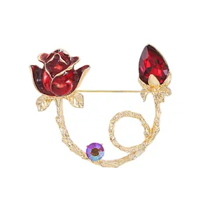 Elegant rose flower enamel brooch with red crystal bud and golden vine branch design.