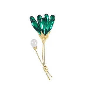 Elegant emerald green K9 glass and pearl flower brooch crafted in 14k gold-plated brass