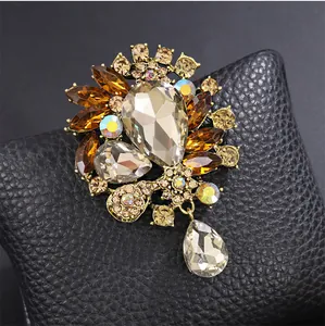 Détail d'une broche de style palais avec cristaux ambrés et pendentif en forme de goutte.