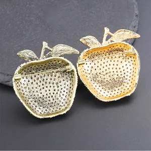 Detail of gold apple brooch back with secure pin fastening and textured finish