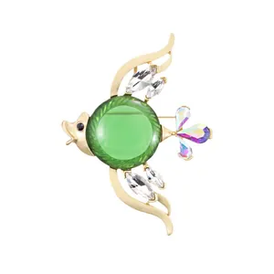 Elegante broche de pez tropical dorado con centro verde y cristales brillantes
