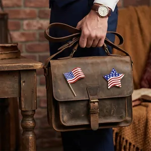 Set of vintage US flag and star enamel brooches displayed on a brown leather bag