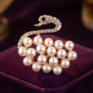 Elegante spilla a cigno con perle bianche e cristalli scintillanti in lega dorata