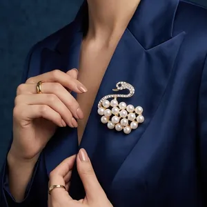 Elegante spilla a cigno con perle e cristalli appuntata su un blazer blu scuro.