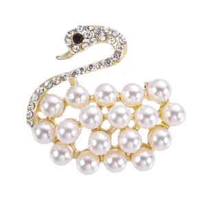 Elegante spilla a forma di cigno dorato con perle bianche e strass scintillanti
