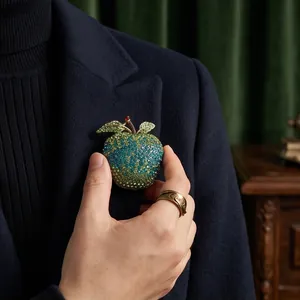 Luxurious green and blue rhinestone apple brooch pinned on a navy suit blazer