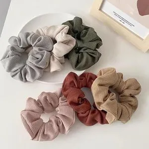 Close-up of soft ribbed fabric hair scrunchies in various autumn retro earth tones