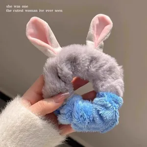 Detail view of a soft plush rabbit ear scrunchie in grey and blue for hair styling