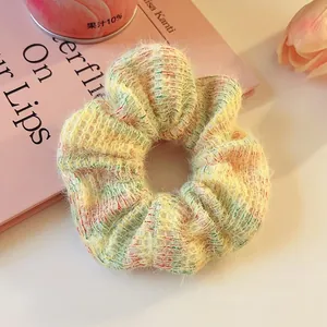 Close-up of fuzzy knit hair scrunchie with colorful yarn texture and soft plush feel