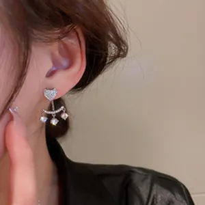 Close-up of elegant zircon magnetic heart earrings for non-pierced ears on a model