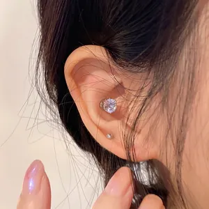 Close-up of sparkling zircon magnetic stud earring worn on ear without piercing.