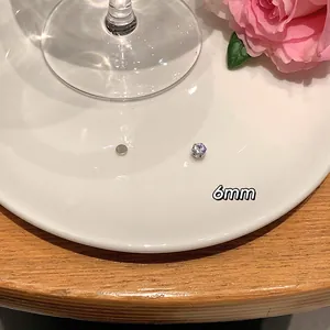 Detailed macro view of 6mm zircon magnetic stud earring on a white plate with a rose