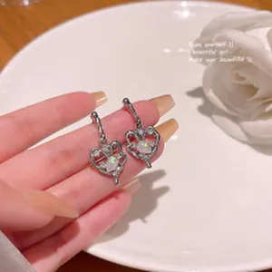 Close-up view of exquisite silver heart stud earrings decorated with sparkling crystals