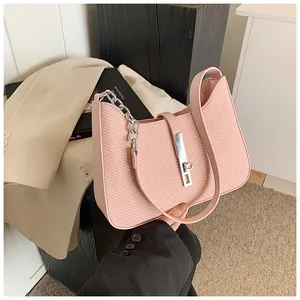 Nahaufnahme einer rosa strukturierten Unterarmtasche mit einer eleganten Silberkette
