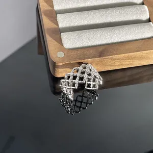 Detailansicht eines silbernen durchbrochenen Rings mit Gitterstruktur und Mikropavé.