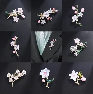 Close-up of various elegant vintage enamel cherry blossom brooches with rhinestones