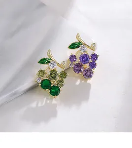 Close-up detail view of elegant sparkling crystal grape brooches in green and purple