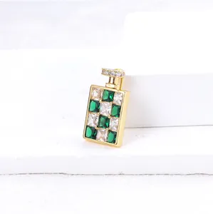 Detailopname van parfumflesje broche met groene en witte zirkonia