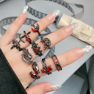 Detailansicht von verstellbaren Ringen im Punk-Stil mit roten Kristallen auf der Hand