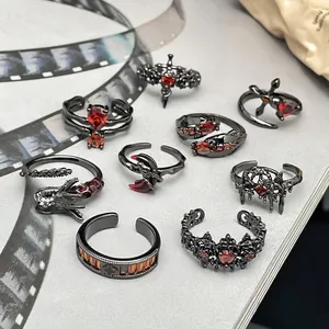 Detailansicht von Punk-Ringen im dunklen Stil mit roten Kristallen und Gothic-Design