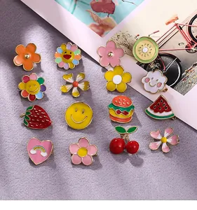 Various cute enamel brooches in flower, smiley and fruit shapes for clothes decoration