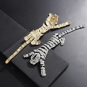 Detail view of luxury rhinestone articulated tiger brooches in gold and silver finish.