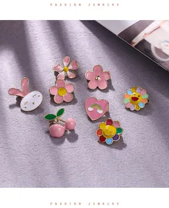 Macro view of cute colorful enamel brooch pins in various floral and animal shapes.
