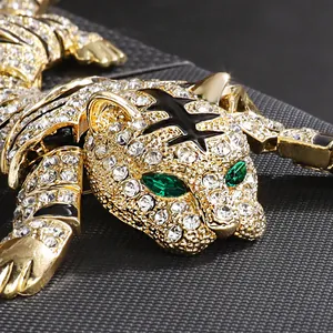 Close-up of heavy industry gold tiger brooch with emerald eyes and white rhinestones.