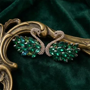 Elegantes broches de cisne con cristales verde esmeralda sobre terciopelo vintage