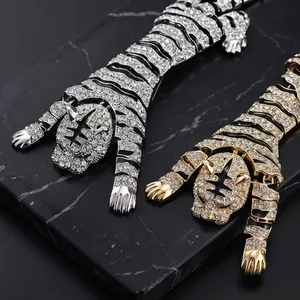 Exquisite luxury rhinestone tiger brooch in silver and gold tones on black marble