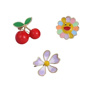 Set of cute enamel pins featuring cherry, rainbow sunflower, and purple flower designs