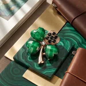Elegant green four-leaf clover brooch with black crystals on a golden stem ornament