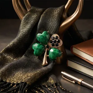 Elegant green four-leaf clover brooch with black crystal accents on gold-tone metal