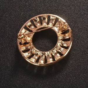 Vintage golden round hollow brooch showing safety pin closure for suits and coats