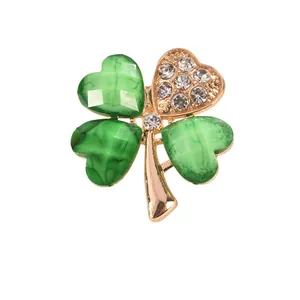 Elegant four-leaf clover brooch with green marble-textured leaves and rhinestones.