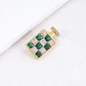 Elegante goudkleurige parfumflesje broche met schitterende groene en witte zirkonia's