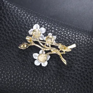 Detail back view of a vintage gold-tone floral brooch with pin clasp on leather