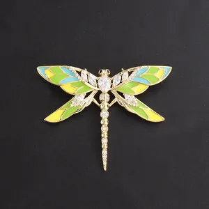 Elegant gold-tone dragonfly brooch with colorful enamel wings and sparkling crystals