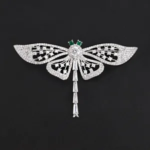 Elegant silver-tone dragonfly brooch featuring sparkling crystals and green stone eyes