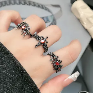 Nahaufnahme von schwarzen Ringen im Gothic-Punk-Stil mit herzförmigen roten Steinen