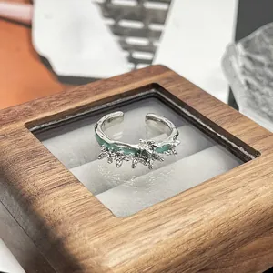 Nahaufnahme eines silbernen Punk-Liquid-Metal-Rings mit minzgrünen Emaille-Schmetterlingen